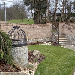 Forged well cover and railing in the garden of afamily home