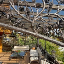 Luxusní ručně kovaná terasa s designem přírody zařízená kovaným nábytkem a svítidly