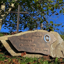 Náhrobný kameň s kovaným krížom, tabuľou s nápismi a fotografiou a dekoračnou ružou