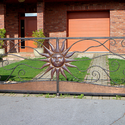 Kovaná brána s tepaným slnkom vyrobená pre rodinný dom