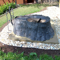 Kunstvolle Feuerstelle, geschmiedet als Baumstumpf mit Eichenkaminbesteck