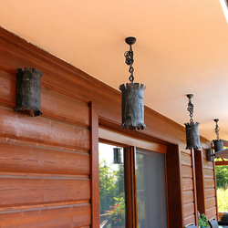 Einzigartige Pendel- und Wandleuchten in Form einer Baumrinde auf der Terrasse eines Landhauses
