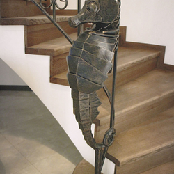 Hippocampe en fer forgé- le détail de décoration d'un garde-corps artisanal.