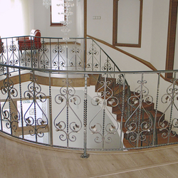 Balustrade et garde-corps d'escalier courbe en fer forgé dans une demeure de prestige. 