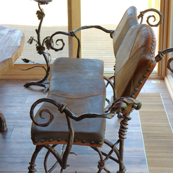 Umělecká lavička s kůží vykovaná v uměleckém kovářství UKOVMI jako součást jídelního nábytku