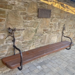 Drevená lavička vložená do ručne kovaných dubových konárov