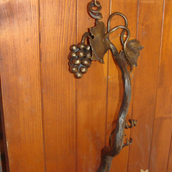 A wrought iron handrail for a wooden gate 