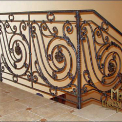 Garde-corps en fer forgé artisanal pour l'escalier sur mesure dans une maison familiale.