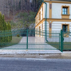 Kovaná brána s bránkou v zelenej farbe so zlatou patinou na Spiši
