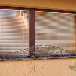 A wrought iron flower holder for a window