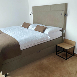 Moderný nočný  stolík v jednoduchom štýle v hotelovej izbe - kovový nábytok