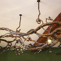 Exkluzivní kované svítidlo s přírodním motivem na recepci hotelu v Tatrách