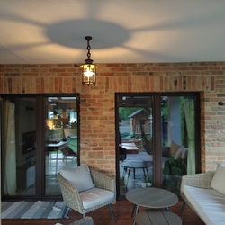 Záhradné kované svietidlo KLASIK/T na terase zladené s celkovým osvetlením rodinného domu